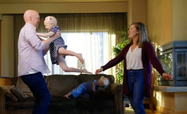 Leighton, a child patient, playing with her parents